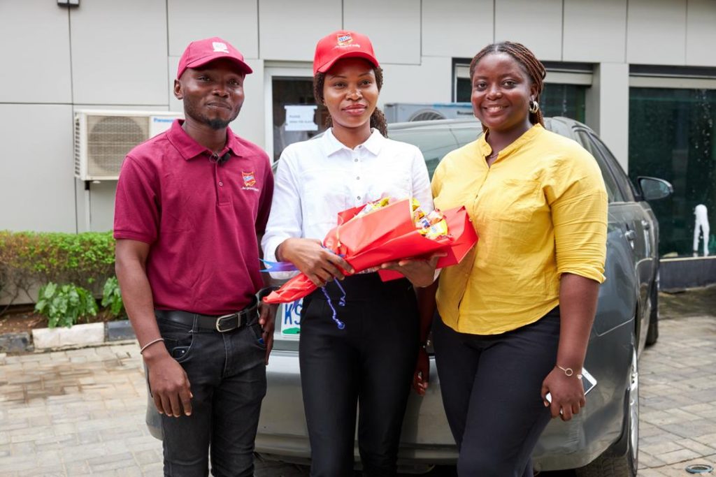 L-R: Olawale Odenusi, Digital Lead and Brand Manager for Rite Sausage Roll Brand; Esther Akinsanya, one of the lucky awardees of the activation and Akinola Mosunmola, Event & Activation Officer, Rite Foods Limited, during the Sausage Rolls Bouquet of Love surprise visit in Lagos.  