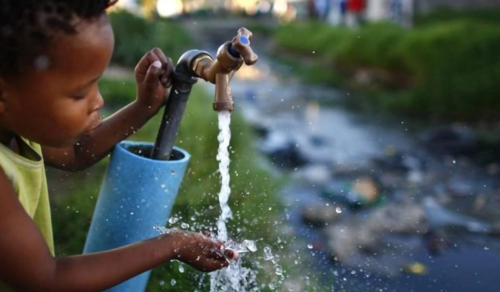 Girl with a running tap of water