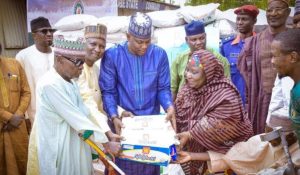 Group picture of 4 men and a woman receiving a bag of rice