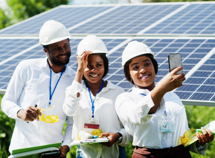 African engineers taking a selfie in front of solar panels, showcasing CSR and renewable energy efforts in Africa