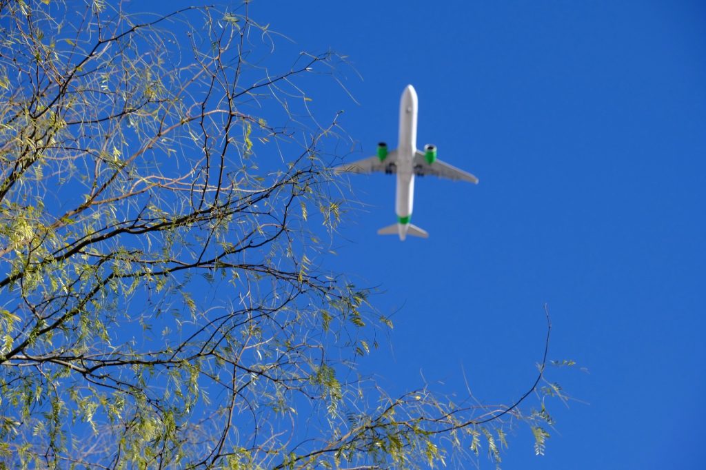 Airplane in the sky with green engines to show cleaner aviation fuel