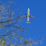 Airplane in the sky with green engines to show cleaner aviation fuel