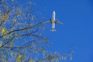 Airplane in the sky with green engines to show cleaner aviation fuel