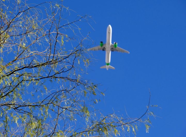 Airplane in the sky with green engines to show cleaner aviation fuel
