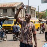 Lagos man pouring water on head under heat wave