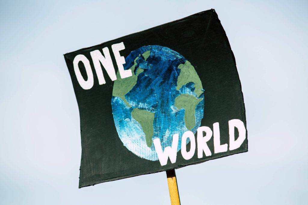 A poster showing one world with the globe of the earth as background