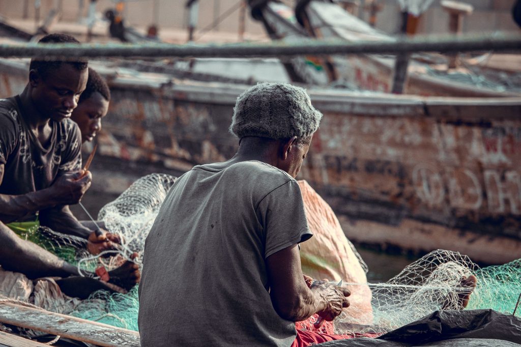 Senegal fishermen repairing nets